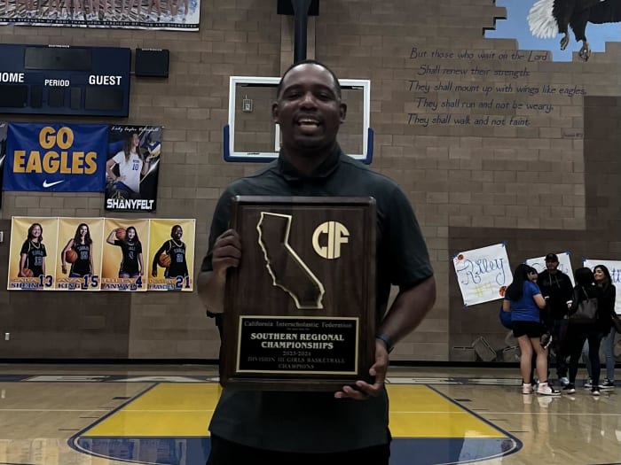 Granada Hills coach Rai Colston poses with the CIF State SoCal regional Division III trophy.